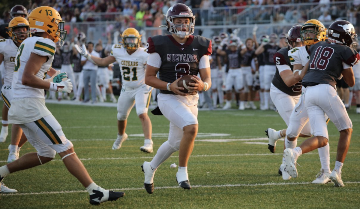 With the help of blocks from Ty Young (5) and Isaiah White (18), quarterback Jack Gordon splits the South defense for a touchdown during the Mustangs' 53-13 Mayor's Cup victory last Friday at Salina Stadium. The Mustangs travel to Ark City on Friday night.